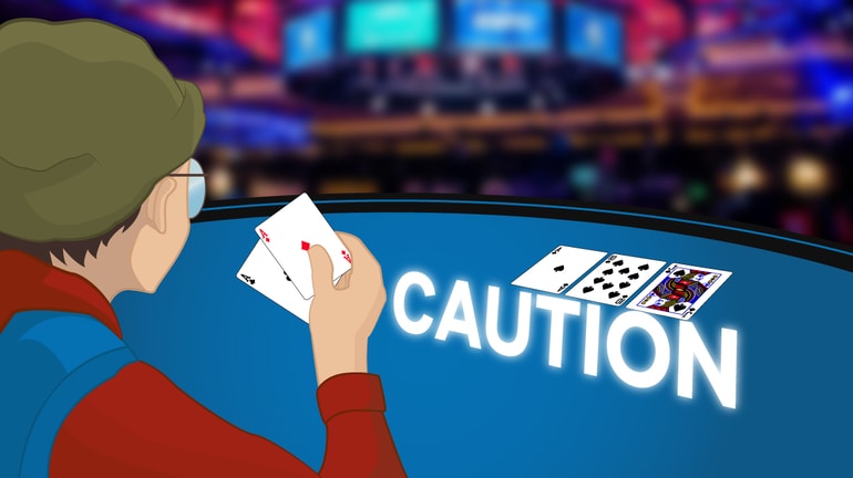 Player holding AdAc on a flop As10sJs with a CAUTION sign